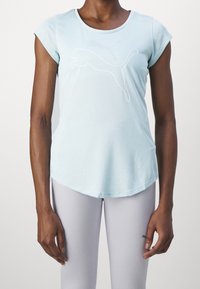 Vaaleansininen urheilupaita, jossa on lyhyet hihat ja pyöristetty helma. Paidassa on valkoinen hyppäävän pumauksen siluetti edessä.