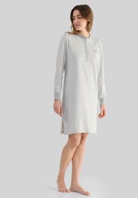 Noche larga a rayas gris y blanca con cuello tipo henley, detalles de botones y aberturas laterales para mayor comodidad de movimiento.