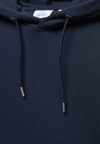 Felpa blu navy in cotone, con un cordino dotato di estremità metalliche e una texture morbida. Etichetta visibile all'collo.