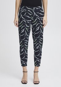 Patterned trousers in navy with white and green abstract designs. Features a slim fit, pleats at the waist, and cropped length.