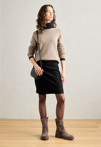 Brown sweater, black fitted skirt, grey suede ankle boots, and a small black crossbody bag. Smooth textures with tailored design elements.