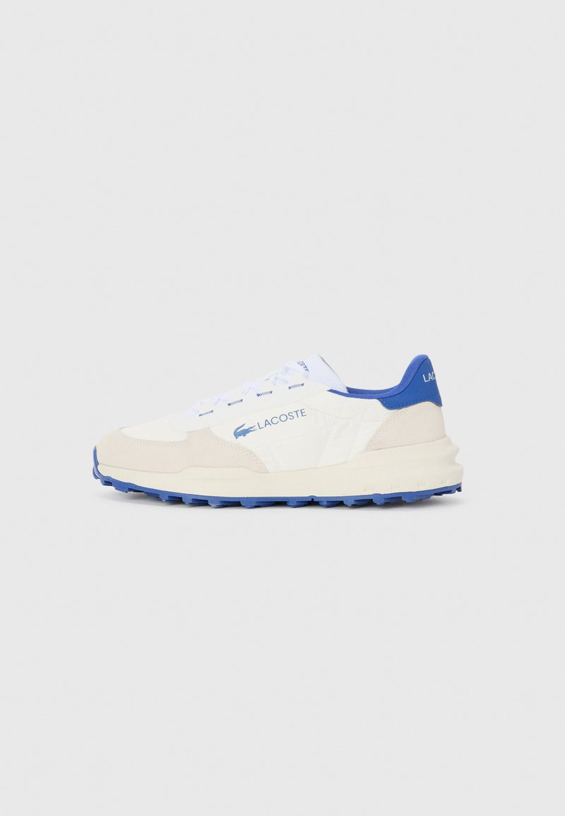 Lacoste sneakers with a white and beige suede upper, blue accents, textured sole, and flat laces, featuring a minimalistic design.