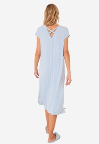 Camicia da notte azzurro chiaro con maniche corte, vestibilità comoda, caratterizzata da un design incrociato sulla schiena e una texture fluida che arriva a metà polpaccio.