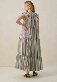 Robe maxi rayée avec des manches volantes, présentant des rayures verticales vert pastel, violet et blanc, et un ourlet évasé à étages.