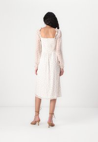Rochie midi ușoară, florală, cu corset elastic, mâneci lungi din material transparent și margini volănașe în culori pastelate delicate.