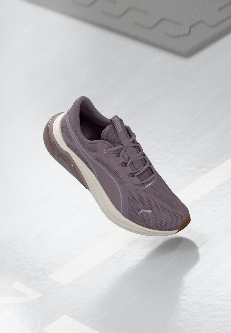 Scarpa sportiva in mesh lilla chiaro con suola ammortizzata, presenta una finitura testurizzata e dettagli in accentuazione leggera. Logo sul lato.