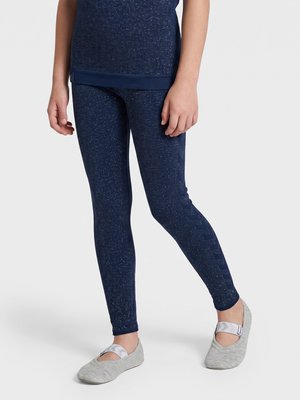 Barn iført mørkeblå leggings med pletter og matchende top, med lysegrå balletsko på en ensfarvet baggrund.