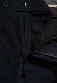 Marineblaue Hose mit einem Frontreißverschluss, Knopfverschluss und flachem Design. Das Innenfutter ist glatt und verfügt über funktionale Taschen.