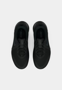 Črni Nike supergi z mrežastim zgornjim delom, ravnim zavezovanjem čipk, teksturirano podplatom in subtilnimi logotipskimi poudarki. Minimalističen dizajn, lahka konstrukcija.