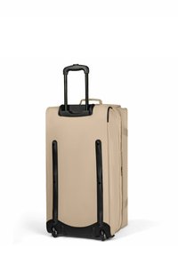 Valigia trolley beige con struttura morbida, manico telescopico nero esteso e due ruote, mostrata in posizione verticale su sfondo bianco.