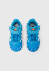 Sinised spordijalatsid võrgumaterjalist pealiskatted, valgete triipudega, reguleeritav rihm, tekstuuriga tald ja oranž aktsent keelel.