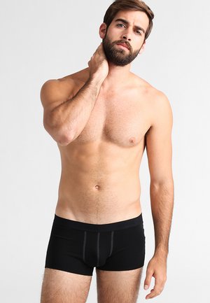 Schwarze Boxershorts aus weichem Material, mit enger Passform, unterstützendem Vorderteil und kontrastierenden Nähten.