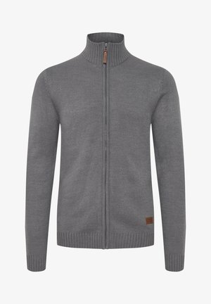 Gray zip-up sweater with a high collar, ribbed texture, and a leather tag on the lower left. Smooth fabric and fitted design.