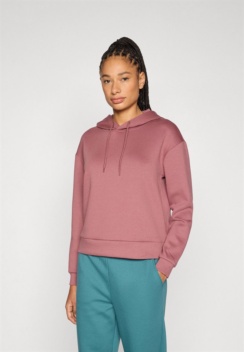 Φούτερ με κουκούλα σε ανοιχτό μοβ με άνετη γραμμή, ριμπ μανσέτες και τελείωμα. Συνδυασμένο με παντελόνια σε τιρκουάζ. Λεία υφή, casual σχεδιασμός.