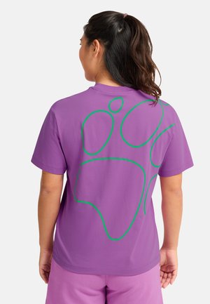 Maglietta di cotone viola con un grande disegno astratto verde sul retro. Maniche corte e vestibilità rilassata. Tessuto dalla texture liscia.