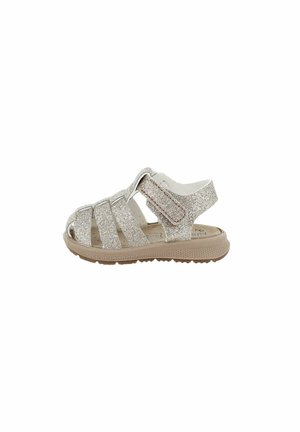 Sandalo neonati con glitter argento, punta chiusa, cinturino regolabile in velcro e suola in gomma beige testurizzata.