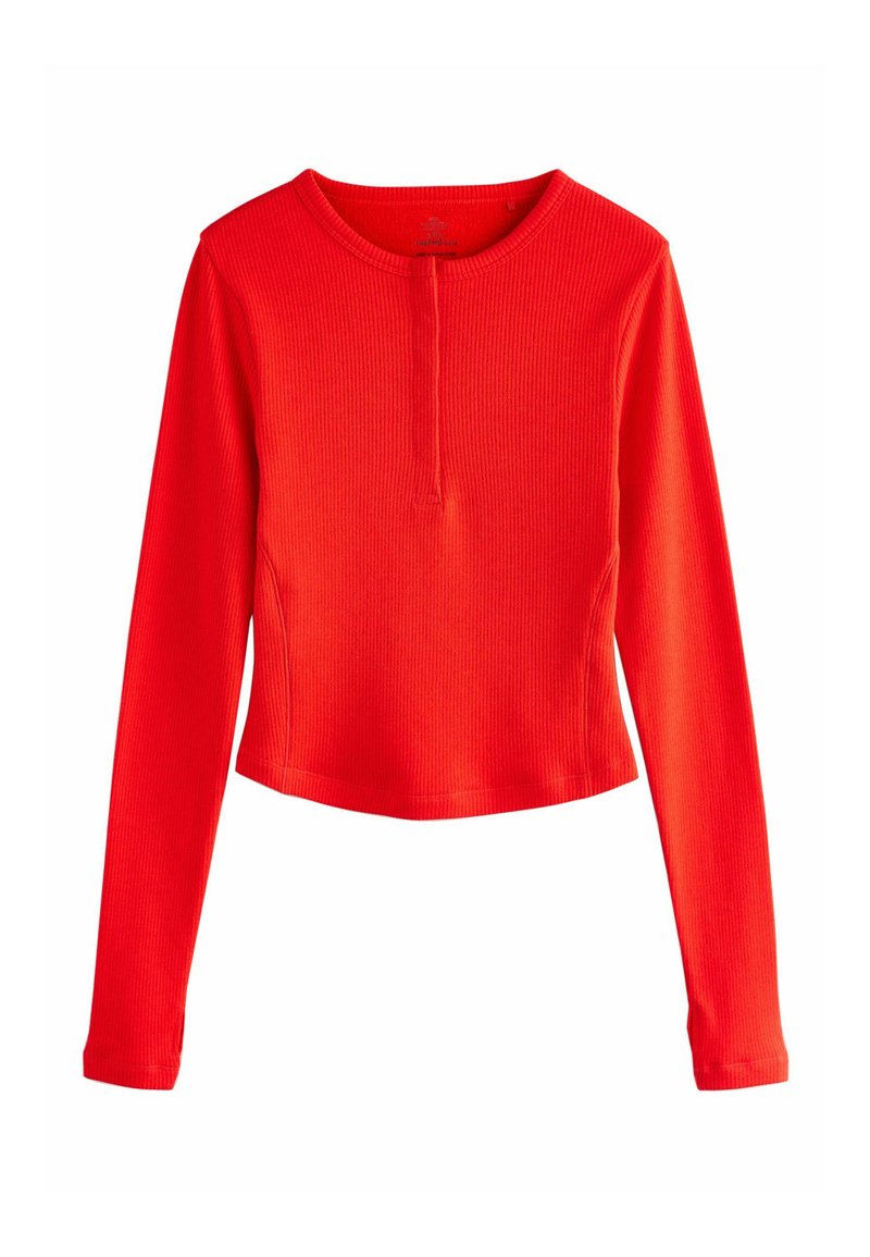 Czerwona, prążkowana bluzka z długim rękawem, o okrągłym dekolcie i skróconym kroju. Gładka faktura z delikatnymi detalami szwów na szwach ramion.