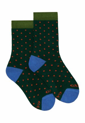 Calzini verdi con pois rossi, rinforzi blu sulla punta e sul tallone, polsino verde a costa, spessore medio, realizzati in una morbida miscela di tessuti.
