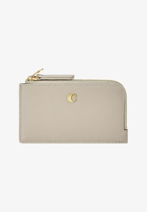 Novčanik od bež kože sa zlatnim patentnim zatvaračem i malim zlatnim emblemom "C" sprijeda, pravokutnog oblika s glatkom teksturom.