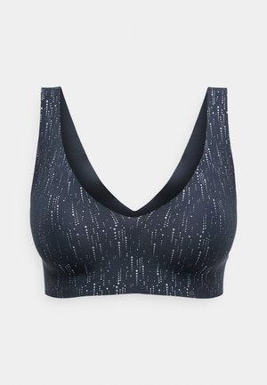 Navy wireless bra with a textured pattern of vertical white dots. Features a deep V-neck and wide straps. Made from a smooth, stretchy material.