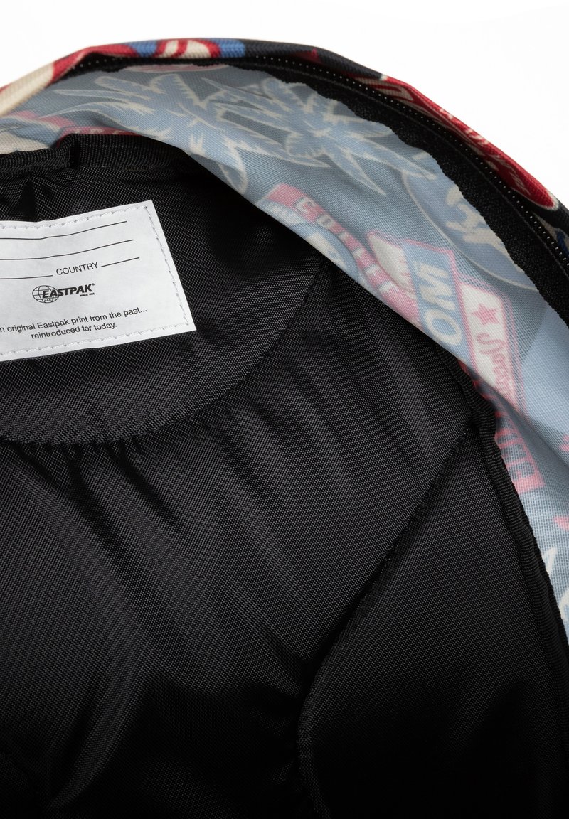 Intérieur d'un sac à dos avec un doublage en tissu noir lisse et un design multicolore de l'autre côté, présentant divers motifs graphiques.