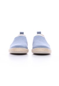 Baskets slip-on en toile bleue avec un bout arrondi, des accents blancs et une semelle en fibre naturelle texturée. Deux languettes à l'arrière pour un enfilage facile.