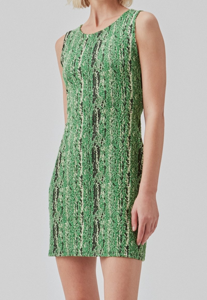 Robe sans manches verte avec un motif texturé ressemblant à des rayures verticales, mettant en valeur des accents sombres et une silhouette ajustée.