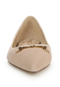 Beige suède puntige ballerina met een gouden metalen decoratieve gesp over de voorkant en een gevoerde zool.