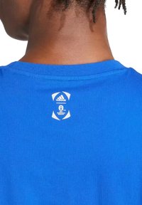 T-shirt di cotone blu con scollo a coste. Presenta un'etichetta con logo bianca sul retro con il logo Adidas e il marchio UEFA Euro 2024.