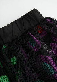 Czerny siatkowy spódniczka z marszczonym pasem, ozdobiona kolorowym wzorem fioletowych, zielonych i czerwonych kształtów, tworzącym warstwową teksturę.