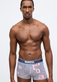 Férfi boxeralsó kék-fehér csíkos mintával és piros grafikával. Puha anyag, elasztikus derékpánt "DIESEL" márkajelzéssel. Testhezálló szabás.