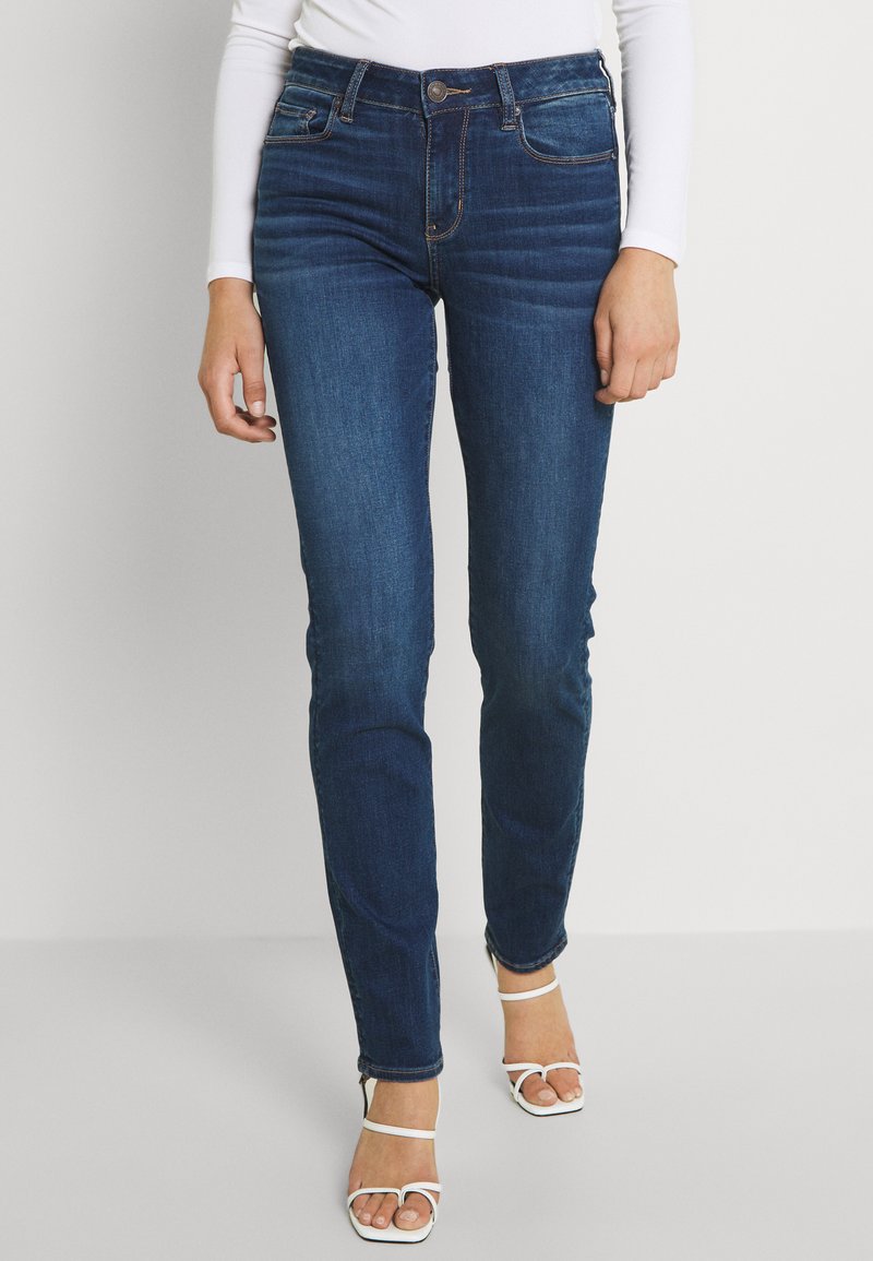 Dunkelblaue Jeans mit Slim Fit, leichter Ausbleichung an den Oberschenkeln, Fünf-Taschen-Design und kontrastierenden Nähten.