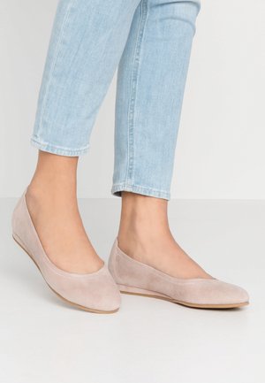 Jasnoróżowe baleriny z zamszu z zaokrąglonym noskiem i prostym wzorem. Miękka faktura i płaskie podeszwy, noszone z jasnoniebieskim dżinsem.