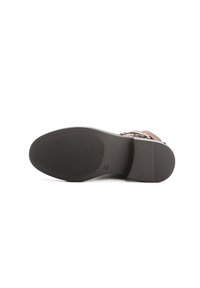 Sandale marron avec une semelle en caoutchouc noir texturé, dotée d'une sangle ajustable et de accents métalliques discrets pour les fermetures.