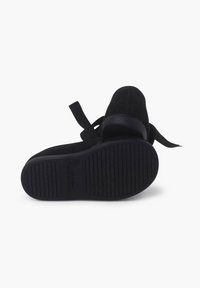 Încălțăminte neagră cu un superior din suede texturat, având un vârf rotunjit și o panglică ajustabilă. Sola din cauciuc are un model striat pentru o aderență mai bună.