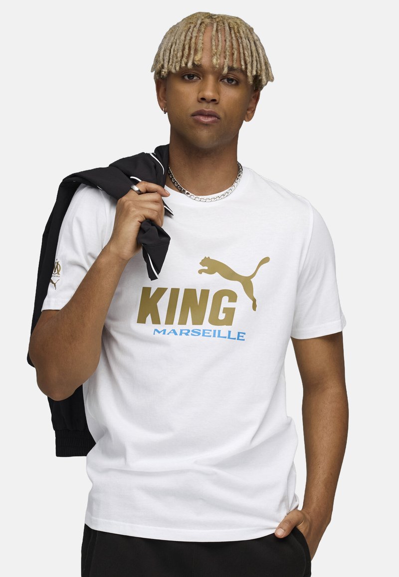 Hvid bomulds t-shirt med "KING" i guld og "MARSEILLE" i blå. Inkluderer et Puma-logo og en slidt katte-silhuet.