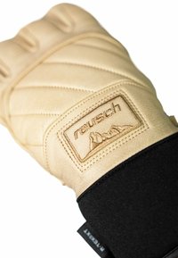 Beige leren handschoen met een gestikte design, versterkte knokkels en een zwarte elastische manchet. Bevat een gemerkte label met een berggrafiek.