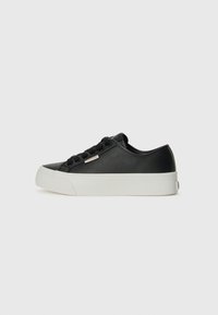 Black leather sneaker with a smooth texture, white rubber sole, round toe, and six black lace eyelets. Features a small metallic logo detail.