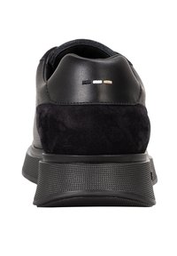 Adidași negri combinați din piele netedă și suede. Au o talpă din cauciuc texturat negru și cusături de accent mici în negru, alb și auriu.