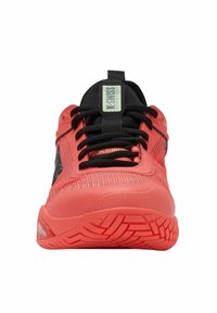 Botte de sport rouge vif avec des lacets noirs, une languette noire et une semelle à motifs, vue de face.