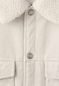 Beige Jeansjacke mit flauschigem weißem Lammfellkragen, ausgestattet mit silbernen Druckknöpfen und zwei Fronttaschen mit Klappen.