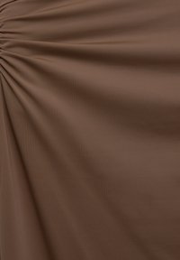 Tessuto marrone con texture arricciata, superficie liscia e leggera lucentezza. Caduta morbida con linee verticali visibili sulla stoffa.