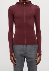 Bordový dlouhý rukáv zipový mikin, přiléhavý design, hladká textura, s otvory na palce v rukávech a minimálním logem na přední straně.