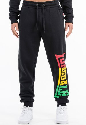 Black cotton sweatpants with a tapered fit, featuring a colorful “Lonsdale” logo in red, yellow, and green down the left leg. Adjustable waistband.