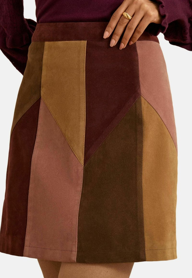 Suède mini-jurk met een geometrisch patchworkontwerp in bruin-, bordeaux- en roz tinten. Soepele textuur met een aansluitende taille.