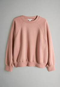 Hanorac roz confecționat dintr-un amestec de bumbac, cu gât rotund, manșete și tiv striate, mâneci raglan și textură netedă.