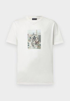 T-shirt en coton blanc avec un imprimé graphique d'une ville, portant le texte et le logo "ARMANI EXCHANGE" en noir au centre. Manches courtes.