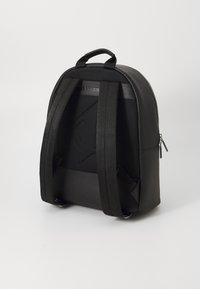 Black backpack with a rounded design. Features textured mesh back, smooth front panel, thick adjustable straps, and side zipper pocket.