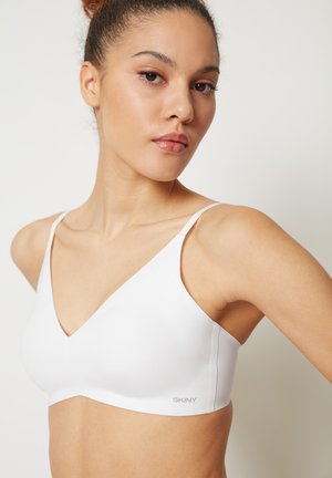 White wireless bra made of smooth fabric, featuring a deep V-neckline, narrow straps, and a subtle logo at the side.
