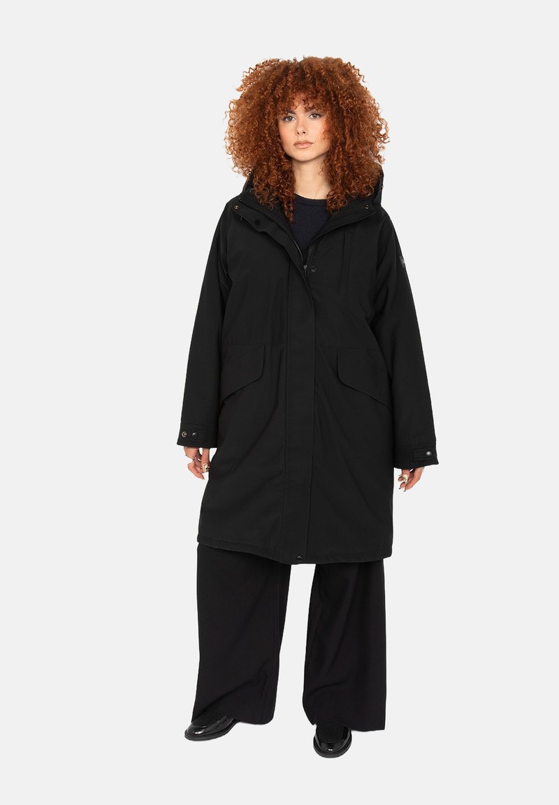 Zwarte lange jas van een gestructureerd, waterproof materiaal, met een capuchon, twee zijzakken en een knoopsluiting. Wijde mouwen en onderkant.